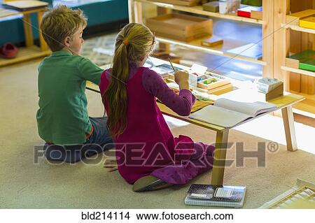 Picture - Caucasian children at table in classroom. Fotosearch