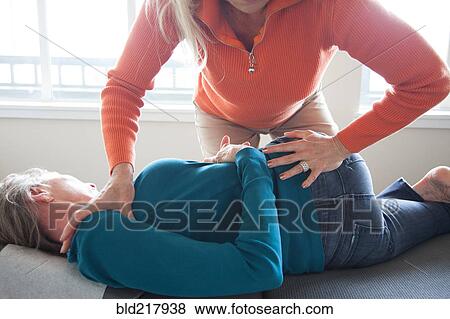 Caucasian chiropractor stretching back of client View Large Photo Image Stock Photo - Caucasian chiropractor stretching back of client. Fotosearch