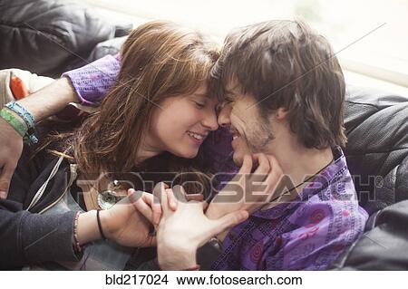Caucasian couple holding hands on sofa View Large Photo Image Picture - Caucasian couple holding hands on sofa. Fotosearch