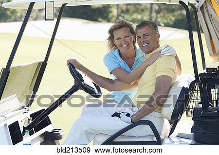 Caucasian couple hugging in golf cart on course View Large Photo Image Stock Photo - Caucasian couple hugging in golf cart on course. Fotosearch