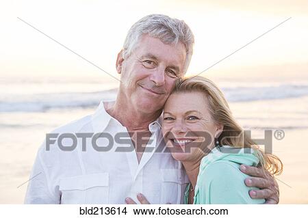 Picture - Caucasian couple hugging on beach. Fotosearch