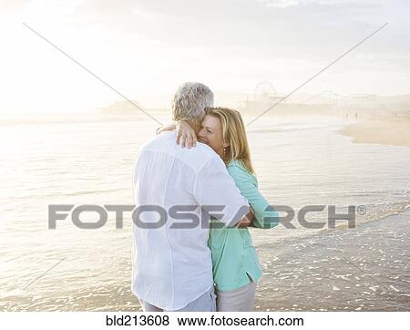 Caucasian couple hugging on beach View Large Photo Image Stock Photo - Caucasian couple hugging on beach. Fotosearch