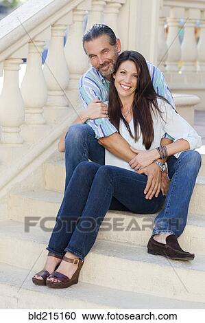 Stock Image - Caucasian couple hugging on front stoop. Fotosearch