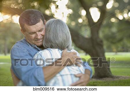 Caucasian couple hugging outdoors View Large Photo Image Stock Photograph - Caucasian couple hugging outdoors. Fotosearch