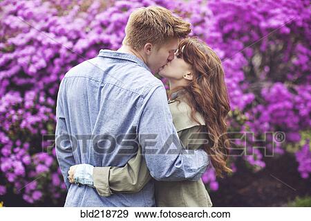 Stock Photo - Caucasian couple kissing in park. Fotosearch