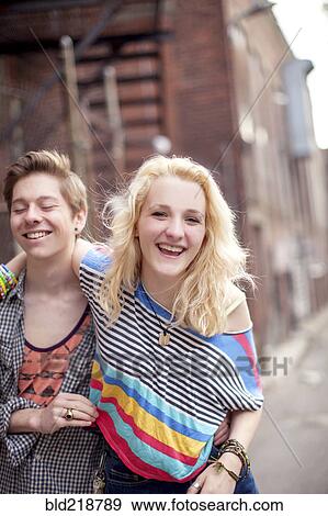 Caucasian couple laughing on city sidewalk View Large Photo Image Stock Photo - Caucasian couple laughing on city sidewalk. Fotosearch