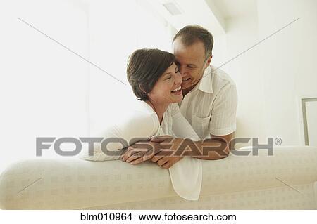 Caucasian couple laughing together on sofa View Large Photo Image Picture - Caucasian couple laughing together on sofa. Fotosearch