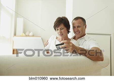 Stock Image - Caucasian couple shopping on line with credit card. Fotosearch