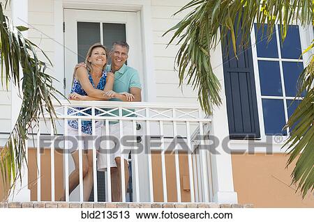 Stock Image - Caucasian couple standing on balcony. Fotosearch