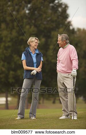 Caucasian couple standing on golf course View Large Photo Image Stock Photo - Caucasian couple standing on golf course. Fotosearch