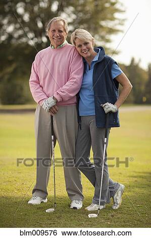 Caucasian couple standing on golf course View Large Photo Image Stock Photograph - Caucasian couple standing on golf course. Fotosearch