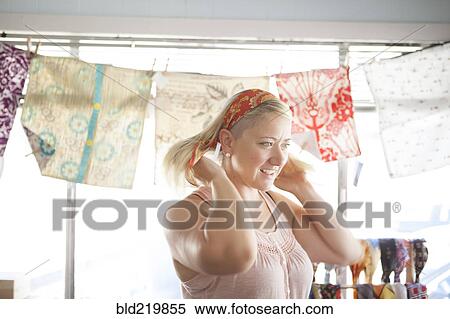 Caucasian customer tying headscarf in store View Large Photo Image Stock Photography - Caucasian customer tying headscarf in store. Fotosearch