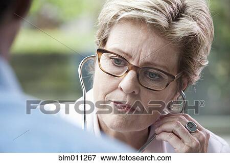 Stock Photo - Caucasian doctor examining patient. Fotosearch