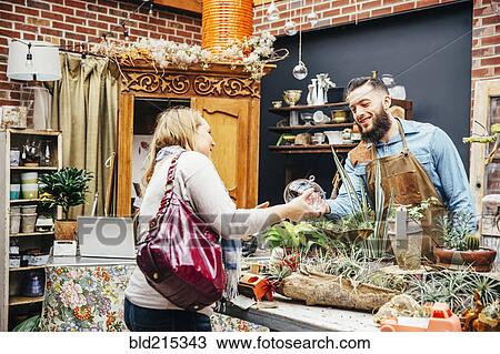 Caucasian employee helping customer in plant nursery View Large Photo Image Stock Image - Caucasian employee helping customer in plant nursery. Fotosearch