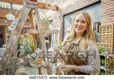 Caucasian employee with plants in nursery View Large Photo Image Stock Image - Caucasian employee with plants in nursery. Fotosearch
