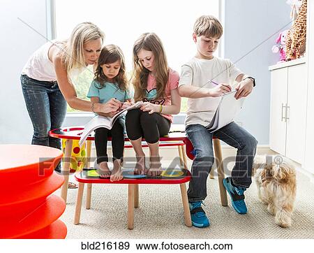 Stock Photo - Caucasian family drawing at table in playroom. Fotosearch