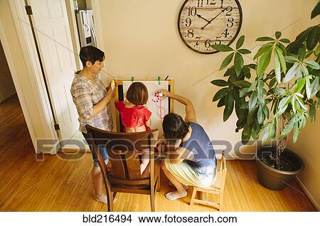 Caucasian family drawing on easel View Large Photo Image Picture - Caucasian family drawing on easel. Fotosearch