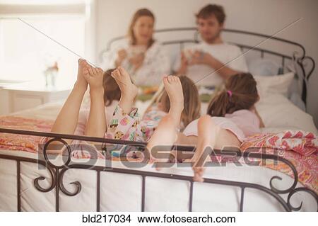 Picture - Caucasian family eating breakfast in bed. Fotosearch