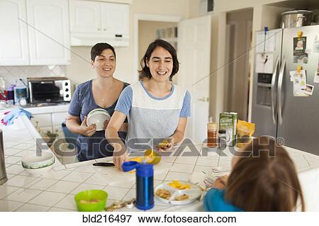 Stock Photo - Caucasian family eating breakfast in kitchen. Fotosearch