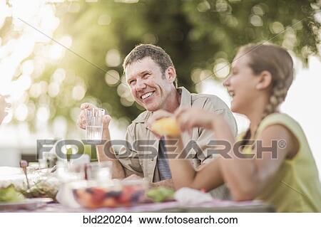 Picture - Caucasian family eating in backyard. Fotosearch