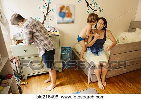 Stock Photography - Caucasian family getting dressed in bedroom. Fotosearch