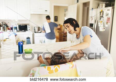 Stock Photo - Caucasian family having breakfast in kitchen. Fotosearch