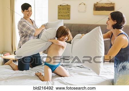 Caucasian family having pillow fight in bedroom View Large Photo Image Stock Image - Caucasian family having pillow fight in bedroom. Fotosearch
