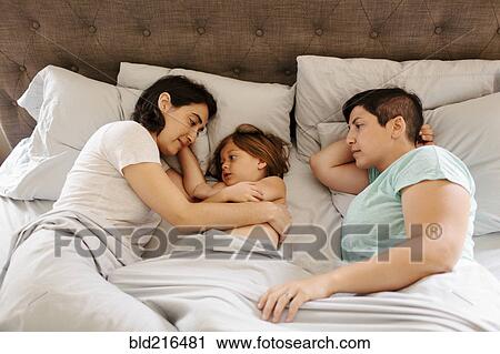 Caucasian family laying in bed View Large Photo Image Stock Image - Caucasian family laying in bed. Fotosearch