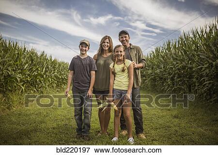 Caucasian family smiling in corn field View Large Photo Image Stock Photo - Caucasian family smiling in corn field. Fotosearch
