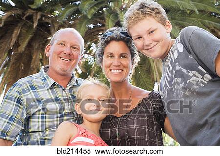 Caucasian family smiling under palm tree View Large Photo Image Stock Photography - Caucasian family smiling under palm tree. Fotosearch