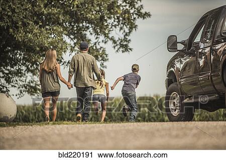Stock Image - Caucasian family walking on farm. Fotosearch