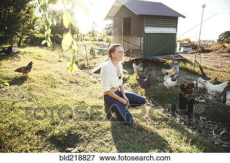 Caucasian farmer crouching by hen house View Large Photo Image Stock Photo - Caucasian farmer crouching by hen house. Fotosearch
