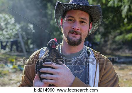 Caucasian farmer holding chicken View Large Photo Image Stock Image - Caucasian farmer holding chicken. Fotosearch