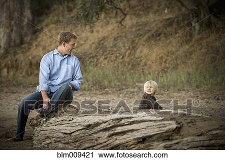 Stock Image - Caucasian father and son enjoying park. Fotosearch
