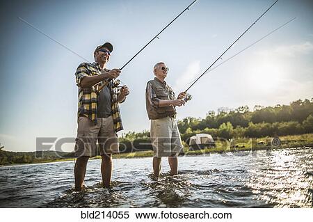 Stock Photography - Caucasian father and son fishing in river. Fotosearch