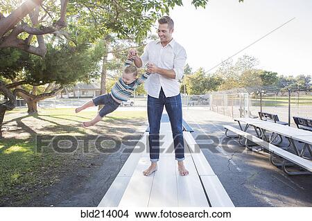 Caucasian father and son playing on picnic table View Large Photo Image Picture - Caucasian father and son playing on picnic table. Fotosearch