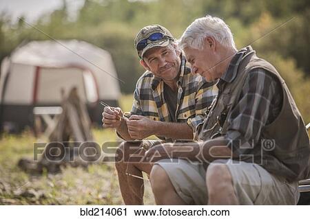Caucasian father and son tying fishing lures at campsite View Large Photo Image Stock Image - Caucasian father and son tying fishing lures at campsite. Fotosearch