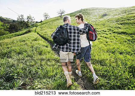 Caucasian father and son walking on dirt path View Large Photo Image Stock Image - Caucasian father and son walking on dirt path. Fotosearch