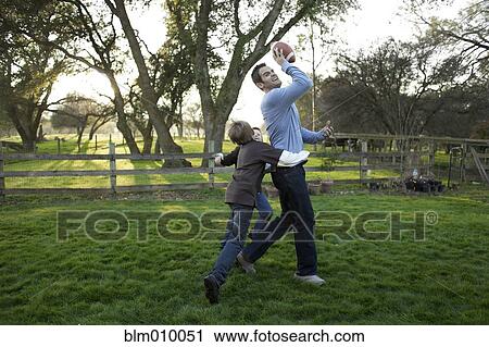 Caucasian father and sons playing football in yard View Large Photo Image Stock Image - Caucasian father and sons playing football in yard. Fotosearch