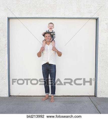 Caucasian father holding son on shoulders in driveway View Large Photo Image Stock Image - Caucasian father holding son on shoulders in driveway. Fotosearch