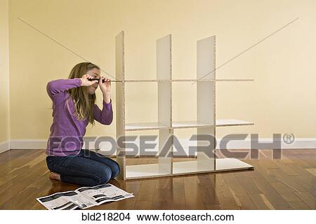 Caucasian girl building bookcase View Large Photo Image Picture - Caucasian girl building bookcase. Fotosearch