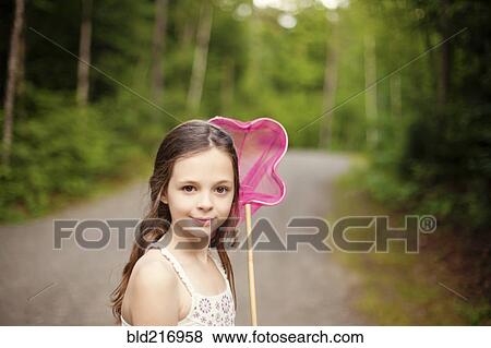 Caucasian girl carrying butterfly net on dirt road View Large Photo Image Stock Photo - Caucasian girl carrying butterfly net on dirt road. Fotosearch