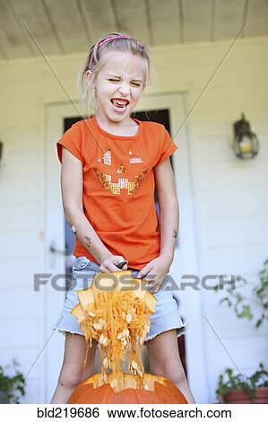 Caucasian girl carving pumpkin on front porch View Large Photo Image Stock Photograph - Caucasian girl carving pumpkin on front porch. Fotosearch