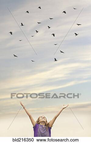 Caucasian girl cheering under flock of birds View Large Photo Image Stock Image - Caucasian girl cheering under flock of birds. Fotosearch