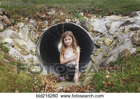 Caucasian girl climbing in storm drain tunnel View Large Photo Image Stock Image - Caucasian girl climbing in storm drain tunnel. Fotosearch
