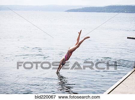 Stock Photo - Caucasian girl diving into lake. Fotosearch