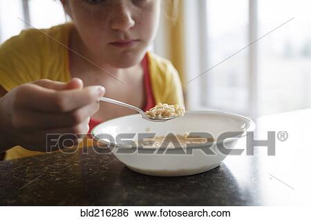 Caucasian girl eating breakfast at table View Large Photo Image Stock Photograph - Caucasian girl eating breakfast at table. Fotosearch