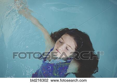 Caucasian girl floating in swimming pool View Large Photo Image Stock Image - Caucasian girl floating in swimming pool. Fotosearch