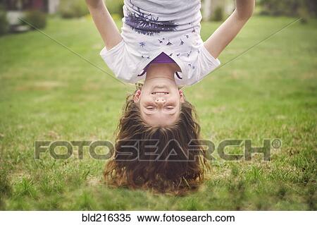 Caucasian girl hanging upside down in backyard View Large Photo Image Stock Photography - Caucasian girl hanging upside down in backyard. Fotosearch