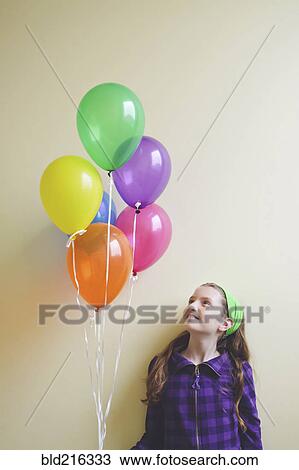 Caucasian girl holding bunch of balloons View Large Photo Image Stock Image - Caucasian girl holding bunch of balloons. Fotosearch